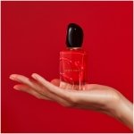 Giorgio Armani Sì Passione Eau de Parfum in its vibrant red bottle, a passionate floral-fruity women's fragrance, held in hand.