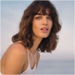 Giorgio Armani Acqua di Gioia Eau de Parfum bottle, featuring a transparent, organically curved glass and an emerald green cap, symbolizing its fresh, aquatic fragrance.